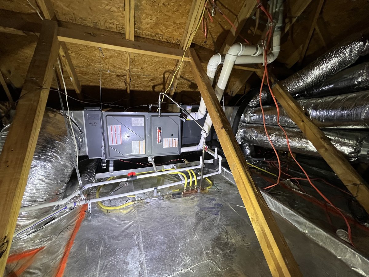 An air handler and ductwork in an attic, serviced by ATC Heating and Air